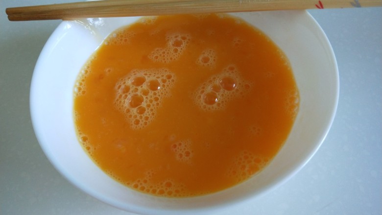 新文美食 黄瓜胡萝卜炒鸡蛋,鸡蛋3个,打入碗中搅拌均匀。