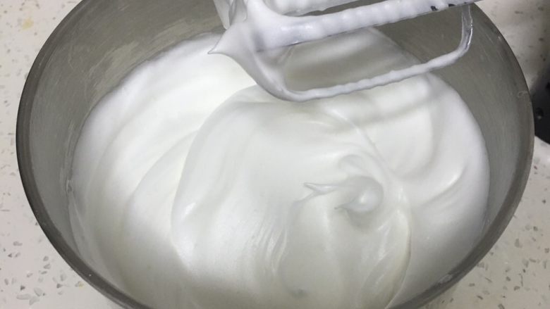荔枝戚风蛋糕,细砂糖分三次加入蛋白中,用打蛋器高速各打三次50圈,蛋白霜硬挺,光滑细腻,蛋白出现直立的小尖峰。