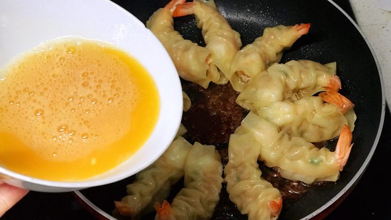 虾饺抱蛋,将蛋液缓缓均匀倒入锅内;