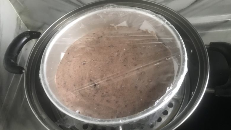 好吃不上火~红豆沙蒸糕,蒸锅烧水至沸腾后,将蛋糕糊放入锅中,表面盖上保鲜膜,防止水蒸气掉在上面。