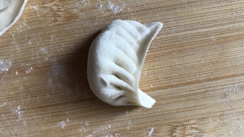 饺子这样做,端上桌肯定倍有面子!,7.捏成月牙饺的形状。
