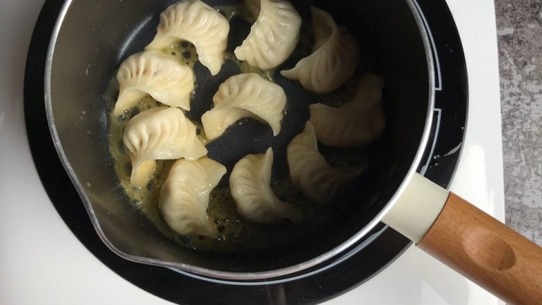 饺子这样做,端上桌肯定倍有面子!,把包好的饺子放入锅底煎至底部微黄,加入没过饺子一半的水量,盖上锅盖煮制