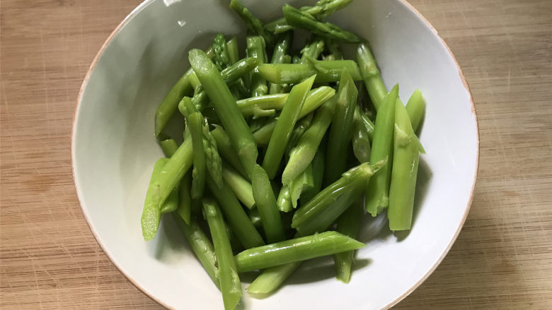胡萝卜炒芦笋,把焯过水的芦笋捞出后过冷水,然后切成小段。