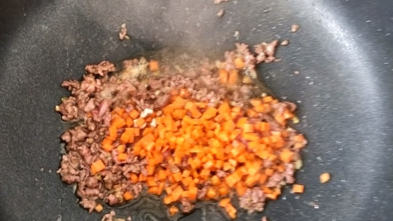 咖喱牛肉炒饭,待牛肉变色后,放入胡萝卜。