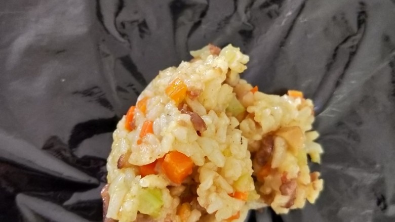 咖喱牛肉炒饭,待炒饭稍微晾凉后,在桌面铺一张保鲜膜,放上适量炒饭。