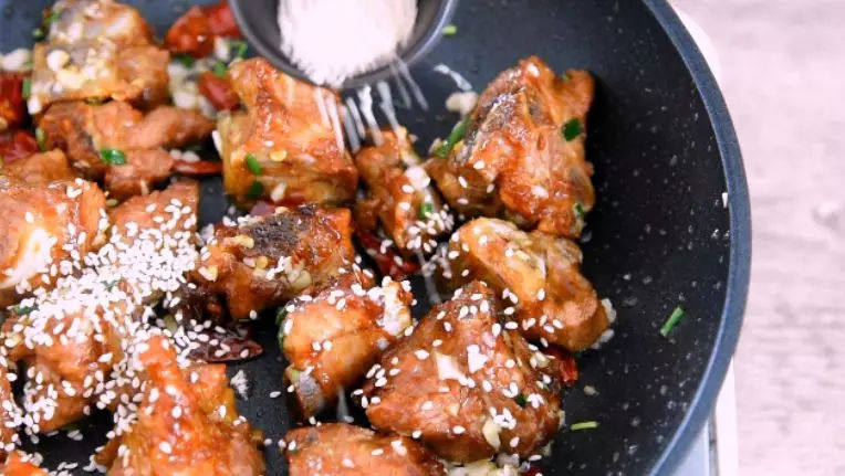 芝麻排骨，香酥入味，一出锅就被吃光！,加入辣椒段炒香，再倒入排骨翻炒