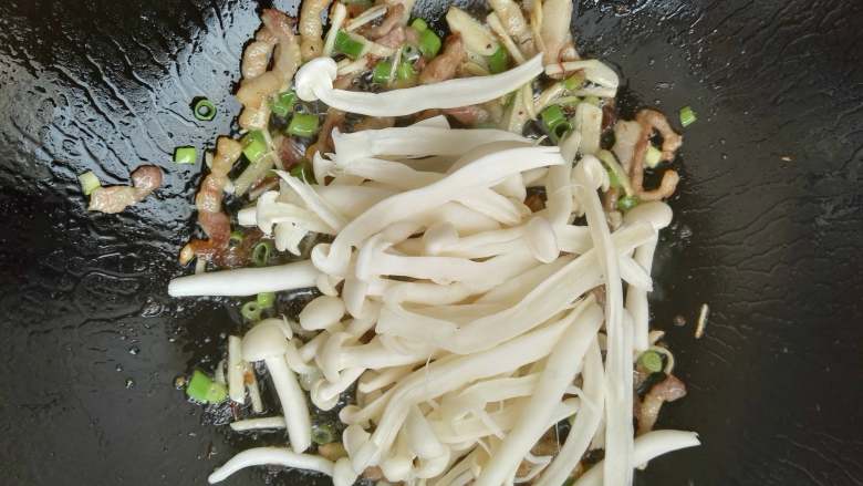 香而不腻、好吃又下饭的白玉菇荷兰豆炒五花肉,加入白玉菇,翻炒均匀。