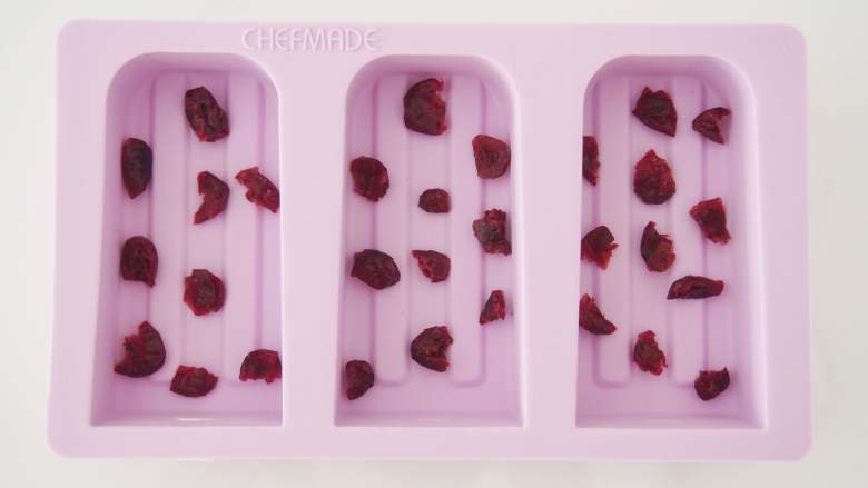 水晶冰糕,模具刷上一层油防粘,在底部铺上切碎的<a style='color:red;display:inline-block;' href='/shicai/ 660'>蔓越莓</a>。