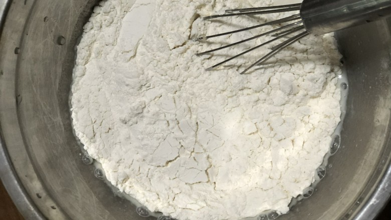 牛奶玉米发糕,加入<a style='color:red;display:inline-block;' href='/shicai/ 519'>面粉</a>，搅拌到没有颗粒状。