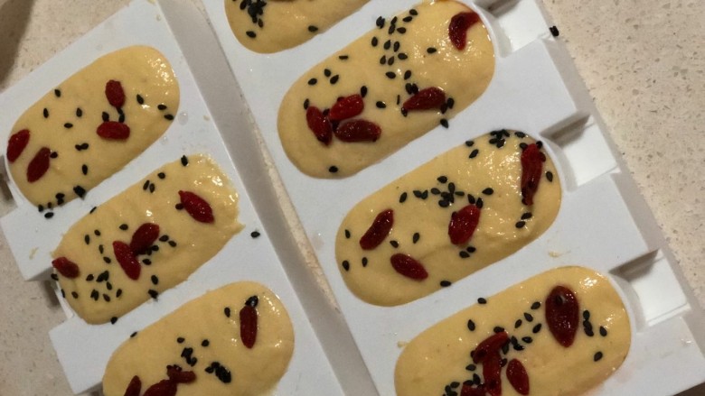 牛奶玉米发糕,入模，撒上芝麻、<a style='color:red;display:inline-block;' href='/shicai/ 673'>枸杞</a>。