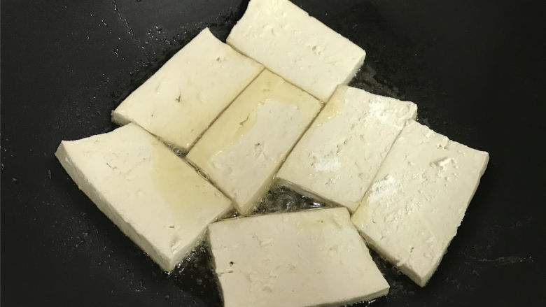 八宝酱豆腐,7成热时把沾上面粉的豆腐放入锅中。