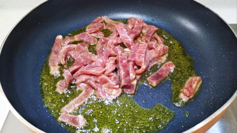 青椒胡萝卜炒牛排,油熟放入牛肉条翻炒