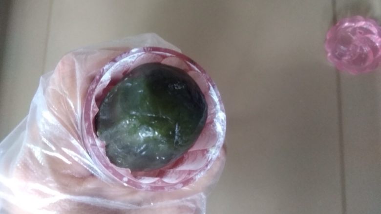 抹茶桃山月饼,再搓成圆柱形,50克的月饼模具在装有面粉的碗里按压一下,抖去多余的面粉,再放入月饼圆坯