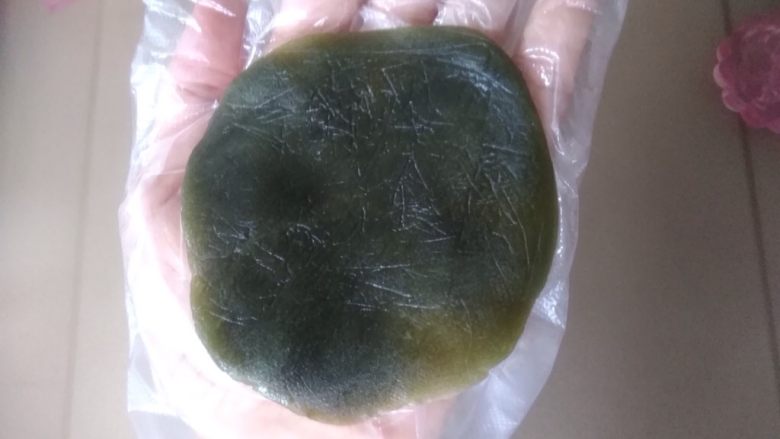抹茶桃山月饼,桃山皮放在手掌上,用另一只手按压,压成四周薄中间厚的圆形