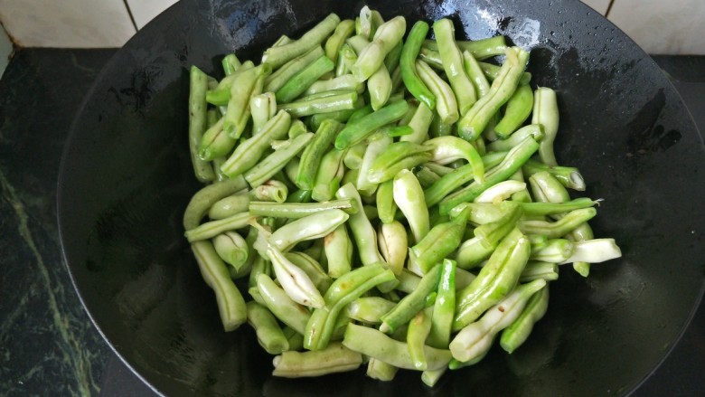 土豆炖豆角,放入豆角翻炒至变翠绿色