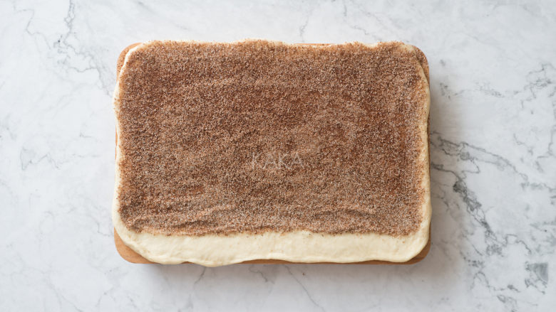 最最好吃的肉桂卷,翻面刷上黄油，撒上肉桂糖，边缘需预留一部分不刷黄油和不撒肉桂糖