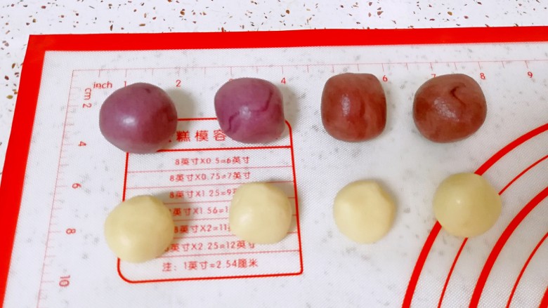 紫薯馅彩色蛋黄酥,把原味的油酥平均分成四份,红色的和紫色的油酥各分成两份。油皮也是平均分成三份,其中一份分成四小份,另外两份各分成两份,分好的油酥和油皮分别搓圆盖上保鲜膜备用。