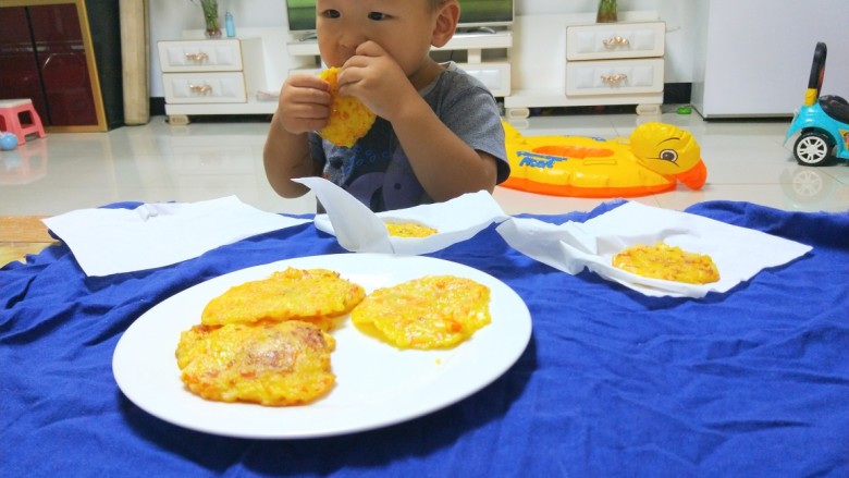 新文美食  胡萝卜土豆饼,等稍微凉一点，宝贝儿拿起来吃，三张吃完了，自己又放三张小饼，我做了七张，宝贝儿一下子就吃光了。