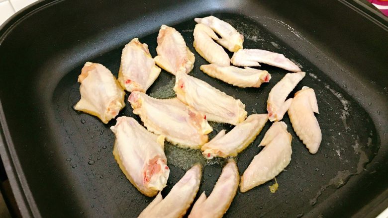 啤酒鸡翅,锅中热油,放入鸡翅煎。