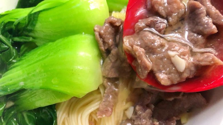 香嫩牛肉面,把烫熟的青菜摆在面条上,浇上牛肉和汤,再放上鸡蛋和香菜即可