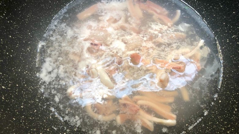 海鲜炒线面,锅里放入一碗水烧开,把鱿鱼放入焯熟,捞起来待用