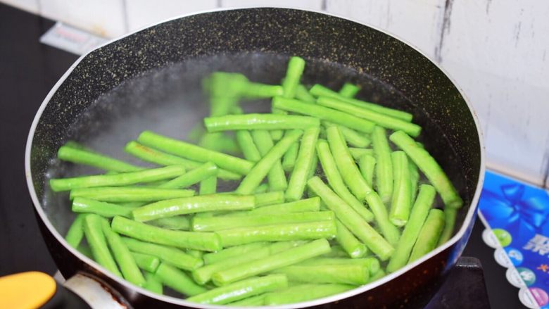 豇豆炒肉,锅中烧开水,倒入少许食用油和盐,再放入豇豆焯水