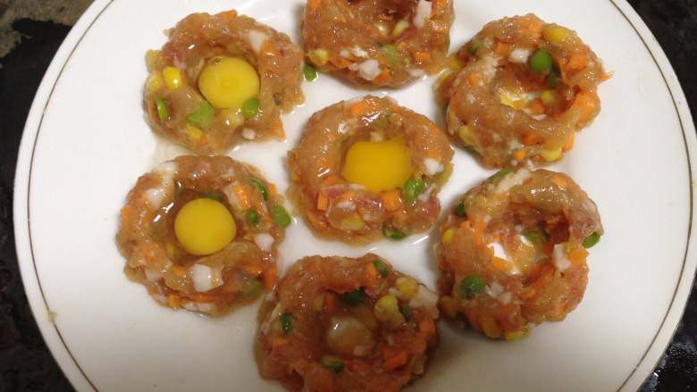 鸡肉玉米蒸蛋,
用手在丸子中间按一个坑,打入一个<a style='color:red;display:inline-block;' href='/shicai/ 12'>鹌鹑蛋</a>