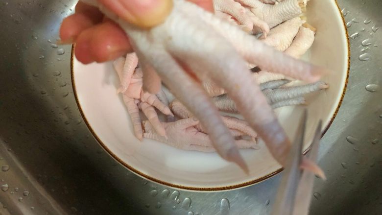 麻辣鸡爪,鸡爪用剪刀剪掉指甲,放入一勺盐搓洗干净