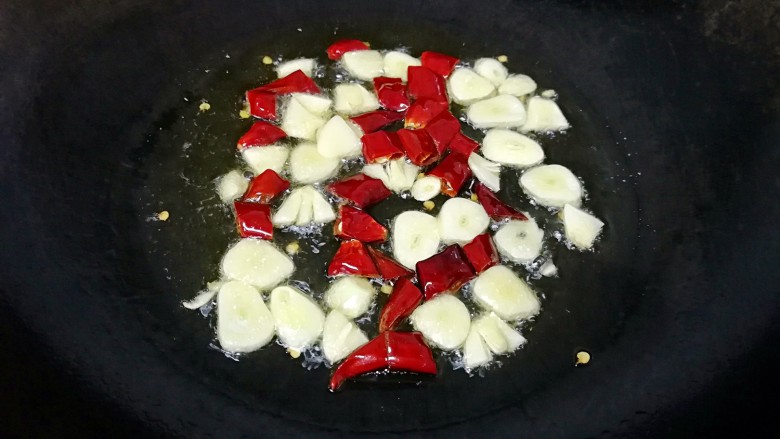 酸辣白菜,炒锅烧热倒入适量的<a style='color:red;display:inline-block;' href='/shicai/ 848'>菜籽油</a>,下入蒜瓣和干红辣椒炒出香味。