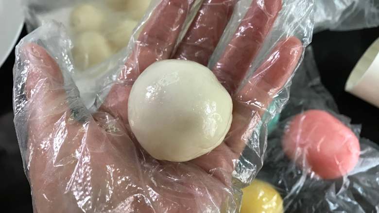 冰皮月饼,然后慢慢地把冰皮往上推,捏紧收口后滚圆。