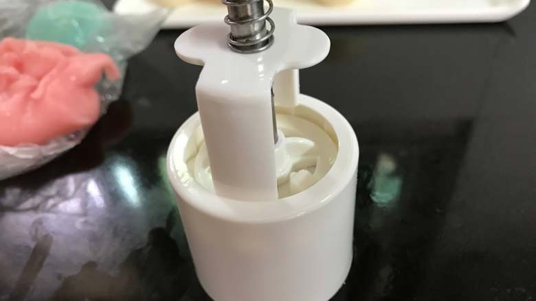 冰皮月饼,放在案板上用力按下,逆时针松开卡住的地方慢慢往上退出模具。