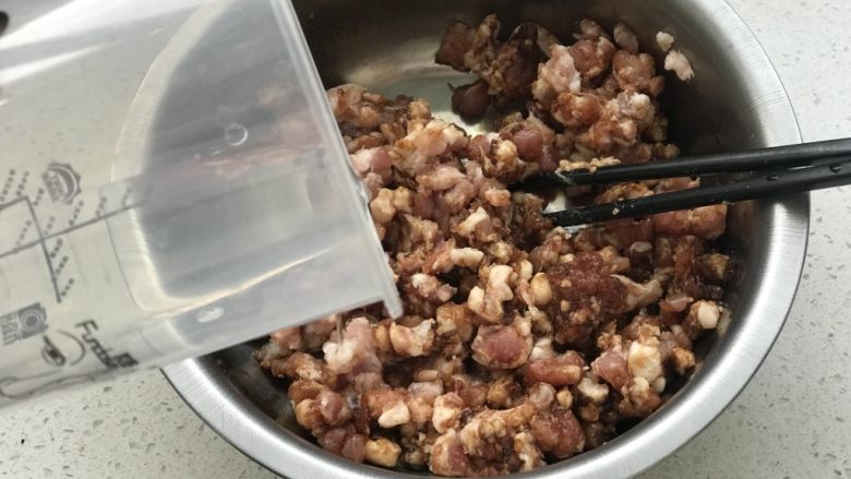 鲜肉月饼,把葱姜取出,用泡好的葱姜水分三次倒入肉馅里搅匀;