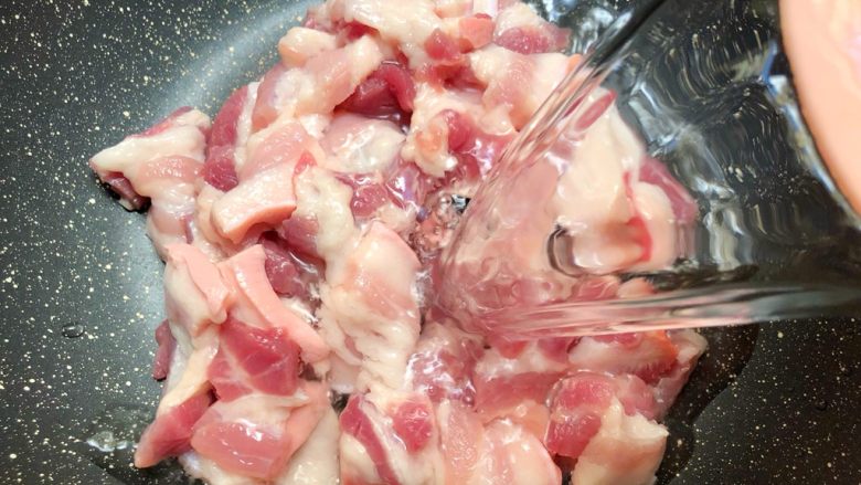 庆元油菜锅,五花肉放入锅里,倒入一碗水,大火烧开