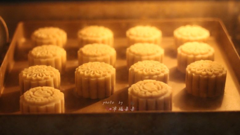 广式五仁月饼,烤箱预热好之后,将烤盘送入烤箱中层烘烤,170~175度上下火先烤8分钟