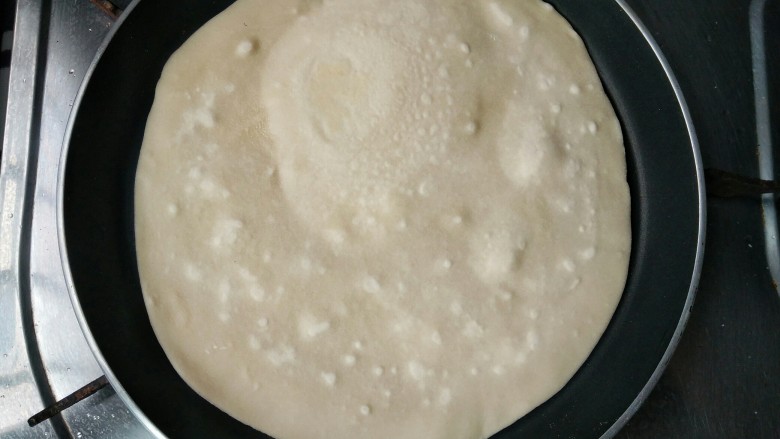锅子饼――滨州名吃,平底锅小火稍微预热一下,放入饼皮。用平锅煎烙,手艺全在对温度的掌握。等到饼中间像吹气球一般鼓起来。