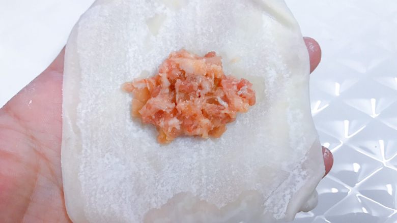 速冻牛肉榨菜元宝馄炖,取一张<a style='color:red;display:inline-block;' href='/shicai/ 10821'>馄炖皮</a>,中间放入适量肉馅,四周抹上清水