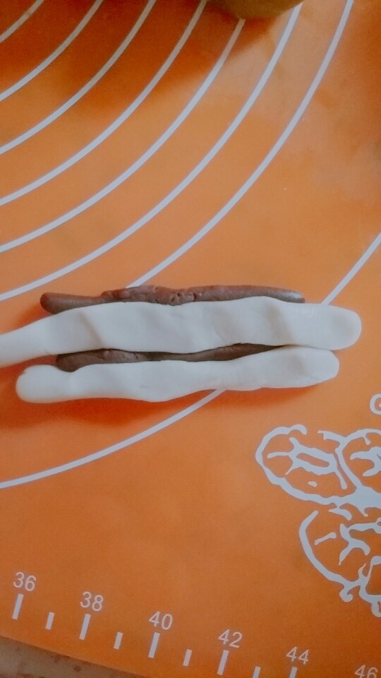 桃山皮月饼,取一份可可桃山皮分成2份,搓成长条,白色桃山皮也分成2份搓成长条,把它们像麻花一样随意扭在一起压扁就可以,(图片当时忘记拍了)