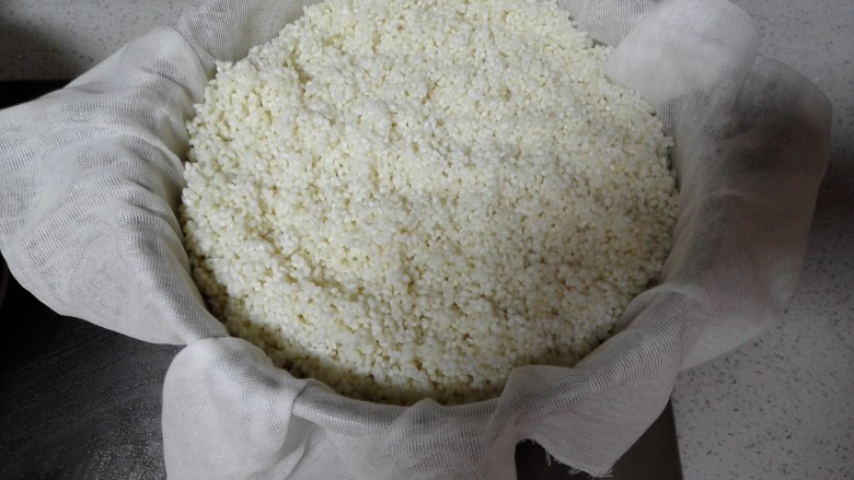 自制酒酿,蒸锅清洗干净,笼屉上铺上干净的纱布,将浸泡好的糯米沥去水后倒入锅里,盖上锅盖大火蒸30分钟。