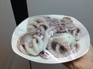 冻章鱼,捞出的章鱼放到盘子里,用保鲜膜封住,然后放到冰水里进行冰镇。