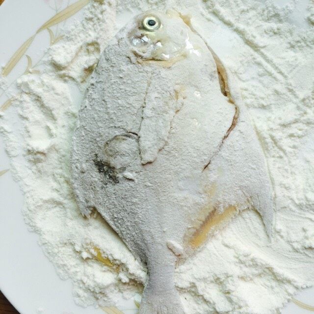 香煎椒盐小鲳鱼,腌制后的鲳鱼用厨房纸擦干水分,取一盘子添加两勺面粉均匀的涂抹鱼身