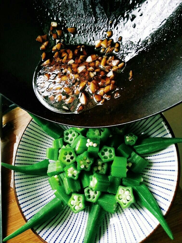 蒜蓉秋葵,将炒好的料汁淋在装盘的秋葵上。