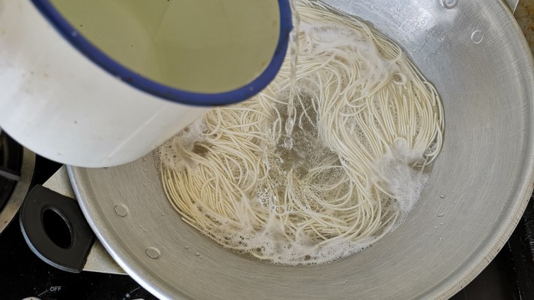 鸟巢蛋面饼,水中倒入少许油和盐煮开,放入适量的面条烧开浇冷水,然后再次烧开即可捞出。