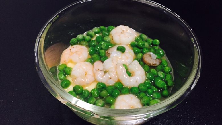 豌豆虾仁鸡蛋羹,把煮好的豌豆和虾仁放在鸡蛋上面