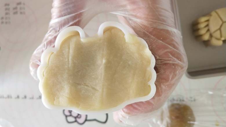 感“蟹”有你—柿饼莲蓉月饼,将椭圆形的月饼坯放入螃蟹模内按压,按压时力气要用足,轻轻压出来的没有重压出来的立体