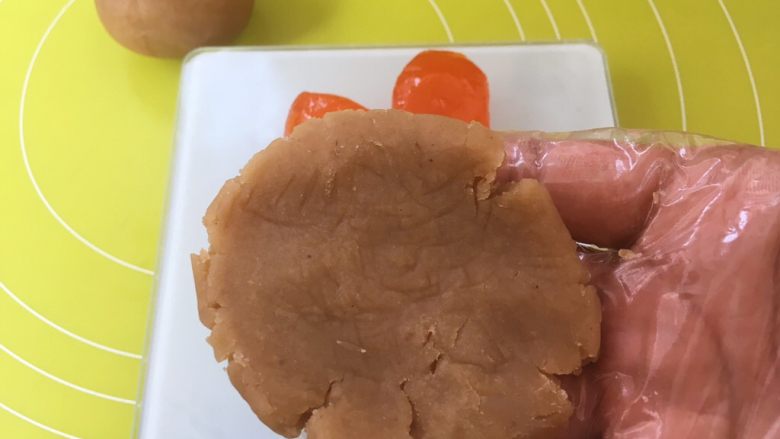 双蛋黄莲蓉月饼,用手掌将莲蓉馅压扁;