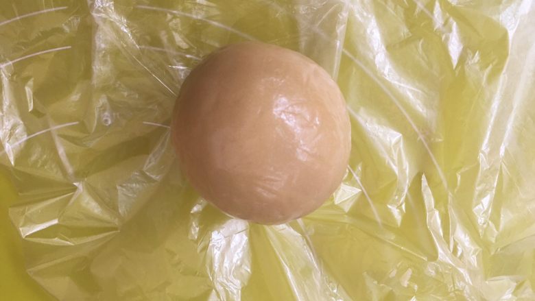 双蛋黄莲蓉月饼,包裹好的月饼用手掌搓圆,表面光滑,如有气泡,可用牙签扎破;