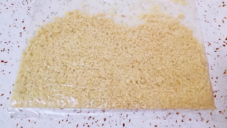 花生小酥饼,花生仁装在保鲜袋里面,用擀面杖碾碎成颗粒状。