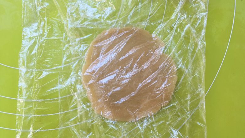爱心金沙月饼,取15克松弛好的面团搓圆,上下盖保鲜膜,用擀面杖擀圆;
