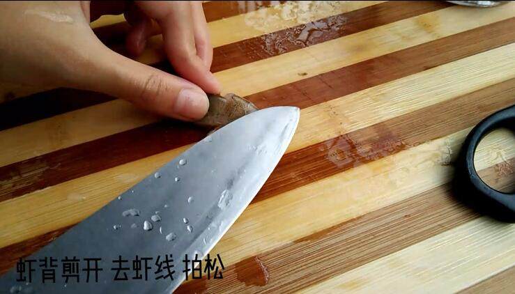 蒜蓉粉丝虾(一看就会!),去掉虾线后用刀背把虾肉拍松 拍松后可以让后面的虾呈开花状