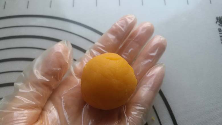流心金沙奶黄月饼,用手指将金沙奶黄馅料中间戳个凹洞,整成像窝窝头一样的形状,挤入冷冻过的流心馅(提早一天把40克流心馅装进裱花袋,放冰箱冷冻备用)